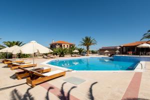 een zwembad met tafels en parasols en een resort bij Acropol Studios in Mithimna