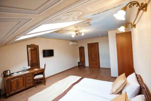 リヴィウにあるMini-Hotel Guest House Inn Lvivのベッドとデスクが備わるホテルルームと