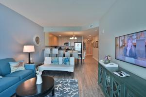 sala de estar con sofá azul y TV en Huge Ocean Front Condo, Amazing Views en Myrtle Beach