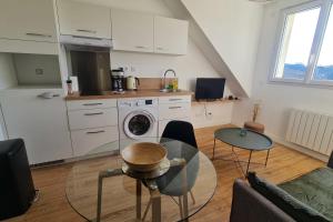 ein Wohnzimmer mit einer Küche mit Waschmaschine in der Unterkunft Le Jaures 6 - T2 - Dernier Etage in Hennebont