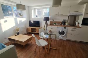 een woonkamer met een tafel en een keuken bij Le Jaures 2 - T2 - RDC in Hennebont