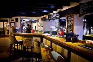 a bar in a restaurant with chairs and a counter at The Bull Hotel in Downton