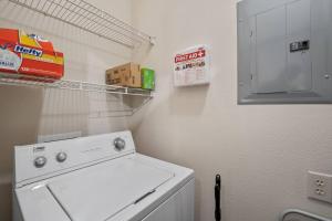 a laundry room with a white washing machine and a shelf at HEIRS VENTURES : Patriot . Near Civic Center . Museum . OKC Thunder Arena . With Washer and Dryer in Oklahoma City
