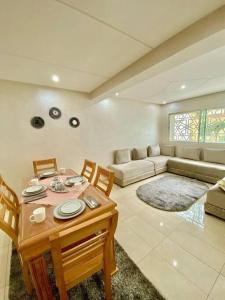 a living room with a table and chairs and a couch at Cozy duplex in Rabat