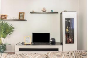 a living room with a couch and a flat screen tv at Home Away From Home in Caniçal