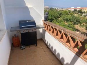 ein Grill auf einem Balkon mit Aussicht in der Unterkunft Lägenhet högst upp, med pool och utsikt över havet in San Luis de Sabinillas