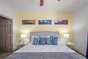 una camera da letto con un letto con cuscini blu e 2 lampade di HEIRS VENTURES: Midtown . Near Hospitals . Pets OK* . W/D . 55” TV a Oklahoma City
