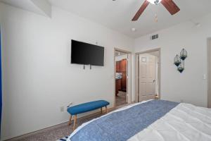 1 dormitorio con 1 cama y TV en la pared en HEIRS VENTURES: Midtown . Near Hospitals . Pets OK* . W/D . 55” TV en Oklahoma City