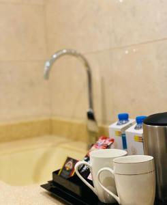 アブハにあるSamaa Eva Resortの洗面台の横のカウンターに座ったコーヒーカップ2杯
