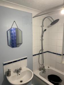 een badkamer met een wastafel, een douche en een bad bij Thames River Side Townhouse in Thamesmead