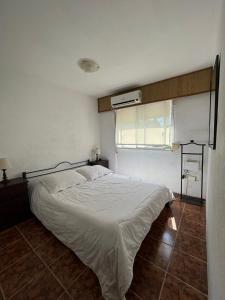 1 dormitorio con 1 cama blanca y ventana en Luna de Mar - cerca del Conrad y parada 7 Playa Brava, en Punta del Este