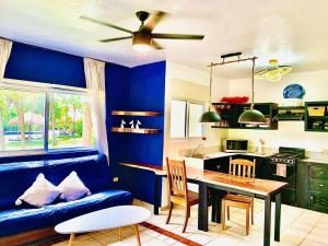 eine Küche mit blauen Wänden, einem Tisch und einem Sofa in der Unterkunft Mayan Riviera Jewel, Private Beach in Puerto Morelos