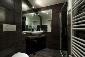 un bagno con lavandino e specchio di Roma Naif Rooms a Roma