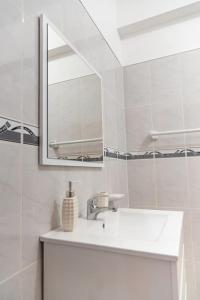 a white bathroom with a sink and a mirror at 3 bedroom apt, Exterior POOL , Cidadela - LCGR in Praia +25 photos