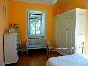 1 dormitorio con paredes de color naranja, 1 cama y ventana en B&B Quarto Rosa Estilo Romântico 