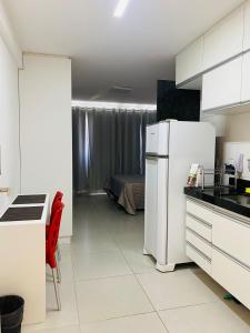 a kitchen with a white refrigerator and a bedroom at Estúdio no Polo Médico do Recife, Ap.804 in Recife