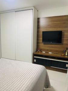 a bedroom with a bed and a flat screen tv at Estúdio no Polo Médico do Recife, Ap.804 in Recife