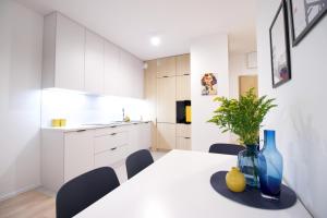 a kitchen and dining room with a white table and chairs at Hygge Malta - NOWY apartament in Poznań