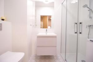 a white bathroom with a sink and a shower at Hygge Malta - NOWY apartament in Poznań