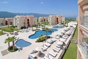 uma vista aérea de um resort com 2 piscinas e espreguiçadeiras em Private Dublex in Wyndham Hotel em Kizilisik