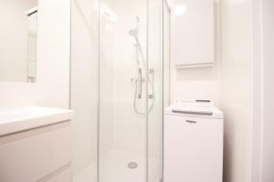 biała łazienka z prysznicem i umywalką w obiekcie Hygge Malta - NOWY apartament w Poznaniu