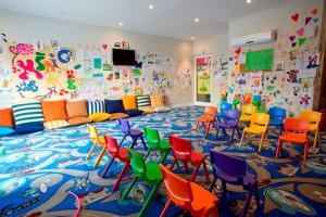 uma sala de aula com cadeiras coloridas e uma sala grande com um mural em Private Dublex in Wyndham Hotel em Kizilisik