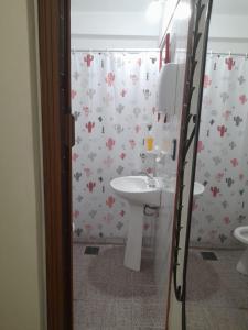 baño con lavabo y cortina de ducha con flores en Dúplex La Nona en Salta