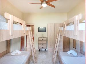 two bunk beds in a room with a ceiling fan at Villa Balcony, Cozy Villa with Amazing View in Rodhiá