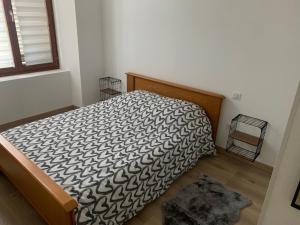 1 dormitorio con 1 cama con edredón blanco y negro en Appartement moderne, en Saint-Mihiel