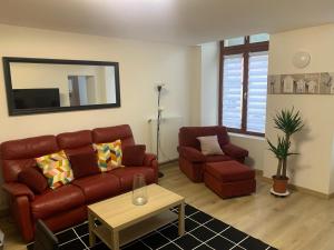 sala de estar con sofá y silla en Appartement moderne, en Saint-Mihiel