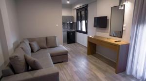 un soggiorno con divano, scrivania e TV di Perla Inn a Stavros