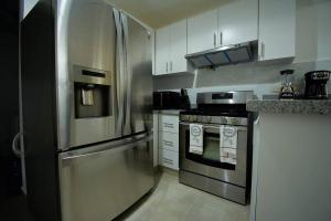 uma cozinha com um frigorífico de aço inoxidável e um fogão em The apartment you dreamed of 2 ! em Santiago de los Caballeros