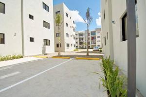 uma rua vazia com edifícios brancos e uma palmeira em The apartment you dreamed of 2 ! em Santiago de los Caballeros