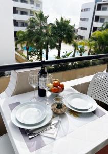 a table with plates and wine glasses on a balcony at Lagos Apartment Ocean View in Lagos