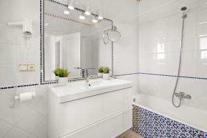 a bathroom with a sink and a tub and a mirror at Villa Atalis in Son Bou