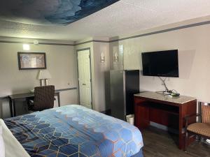 a hotel room with a bed and a flat screen tv at KINGS INN- Medical Downtown Midtown Memphis in Memphis