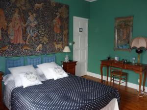 ル・ギルヴィネックにあるMaison d'hôtes Cap Ouestのベッドルーム1室(ベッド1台付)、壁にタペストリーが備わります。