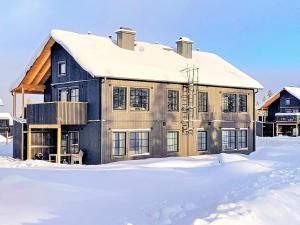 a house with a snow covered roof in the snow at Holiday home SÄLEN XXIX in Stöten