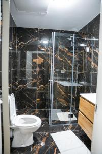 uma casa de banho com um WC e uma cabina de duche em vidro. em Jerusalem Boutique Hotel em Jerusalém
