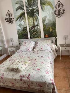 a bedroom with a bed with pink flowers on it at Belle villa entre la montagnette et les Alpilles in Tarascon