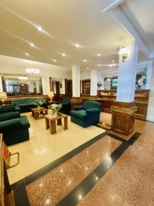 a large living room with green couches and tables at HOTEL CASTELAR CORDOBA in Córdoba