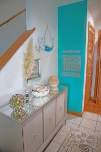 een kamer met een tafel met een strandhuisbord aan de muur bij Lake Front Modern Beach House-Hatteras Island in Avon