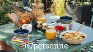 - une table avec petit-déjeuner composé de pain et de jus d'orange dans l'établissement Le petit coin de Provence, à Beaucaire