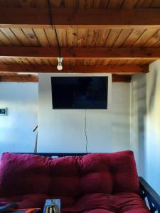 sala de estar con sofá rojo y TV de pantalla plana en Alquileres patagonicos en San Carlos de Bariloche