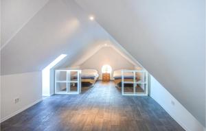a attic bedroom with two beds and wooden floors at 2 Bedroom Awesome Apartment In Loxstedt in Loxstedt