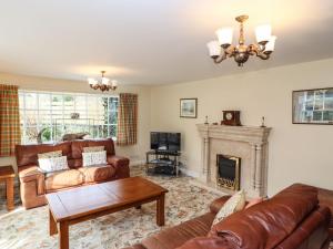 uma sala de estar com móveis de couro e uma lareira em Pavement End Cottage em Grasmere