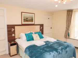 um quarto com uma cama grande com duas toalhas em Pavement End Cottage em Grasmere