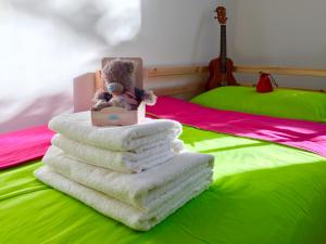 un osito de peluche sentado sobre un montón de toallas en una cama en Cozy Danube Room - 15 mins to Downtown, en Viena