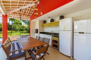 eine Küche mit einem Tisch und einem Kühlschrank in der Unterkunft Quintas de Sauípe - Casa D13 in Costa do Sauipe