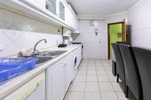 een keuken met een wastafel en een vaatwasser bij Aveiro Cozy Apartment in Eixo